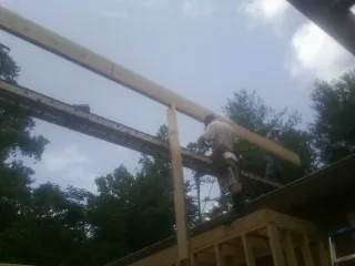 Carpenter setting a ridge beam over a new addition frame — Ice Dam Removal by Roofing Brothers in Spring Run