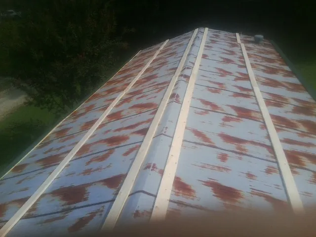 Rusted metal roof panels with new wood purlins before replacement — Storm Damage Roof Repair in Spring Run by Roofing Brothers